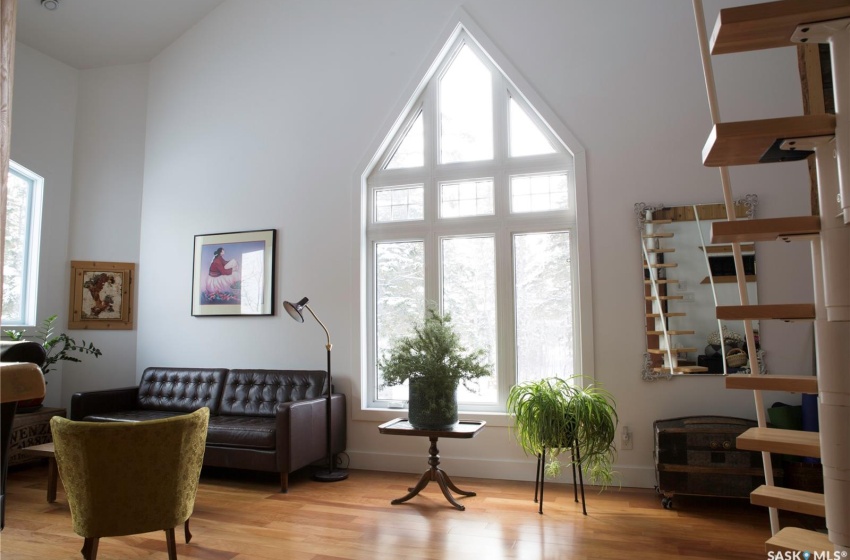 Sitting room featuring baseboards, a high ceiling, and wood finished floors