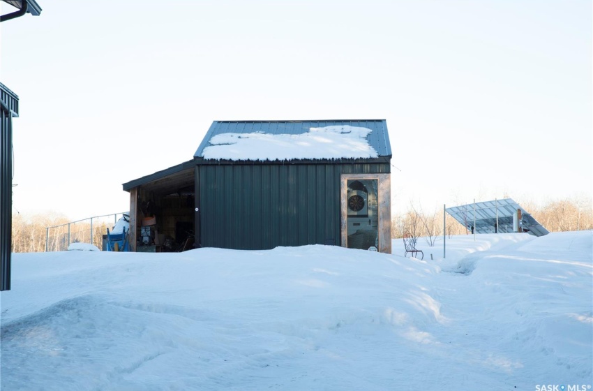 Snow covered structure featuring a pole building and an outdoor structure