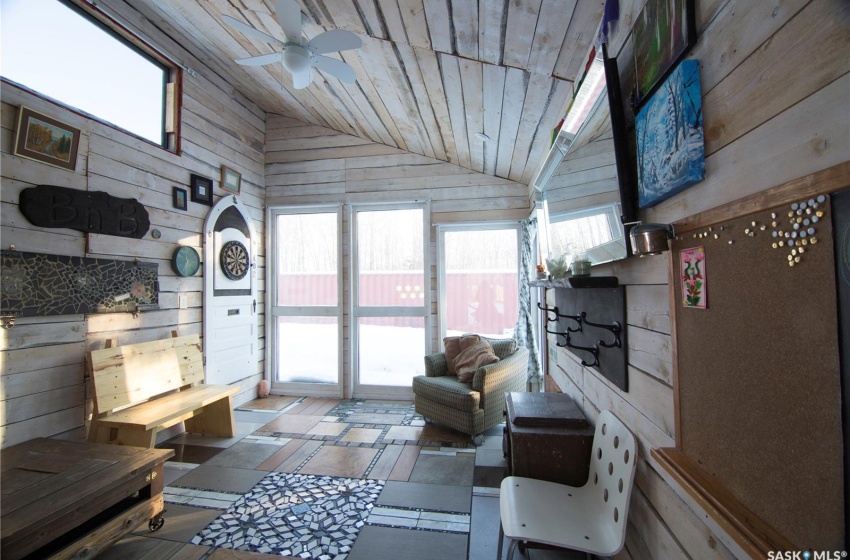 Sunroom / solarium with ceiling fan, wood ceiling, and vaulted ceiling