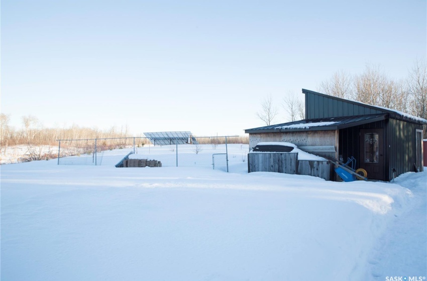 View of snow covered exterior with an outbuilding and metal roof