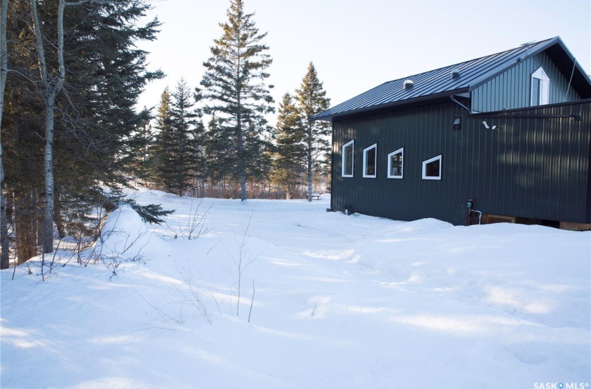 View of snow covered exterior with a standing seam roof and metal roof