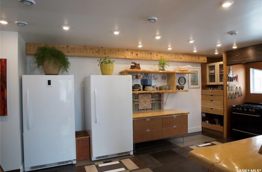 Kitchen featuring black gas range oven, recessed lighting, open shelves, and freestanding refrigerator