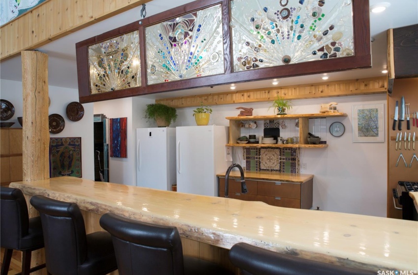 Kitchen with open shelves, a sink, and freestanding refrigerator